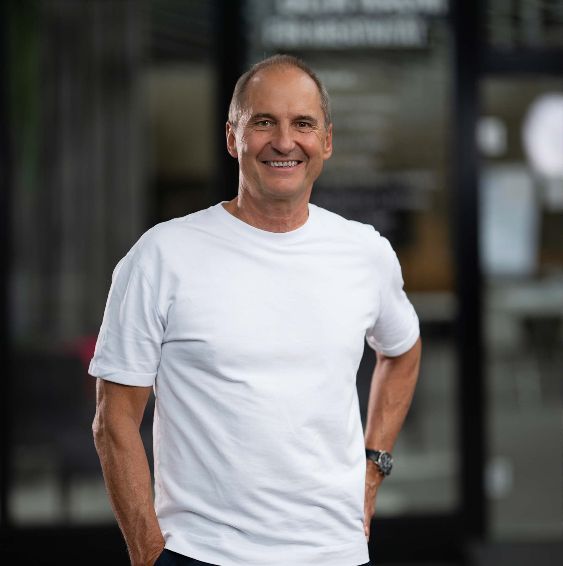 Frank Türke in weißem T-Shirt steht im Kreativraum und lächelt